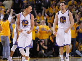 Warriors guards Stephen Curry (left) and Klay Thompson (right) celebrate their victory against the Rockets in Game 2 of the Western Conference final in Oakland, Calif., on Thursday, May 21, 2015. (Cary Edmondson/USA TODAY Sports)
