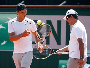 Rafael Nadal and his coach, Toni Nadal (right), attend a training session for the French Open at the Roland Garros stadium in Paris May 22, 2015.  (REUTERS/Vincent Kessler)
