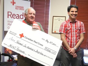 Seventeen year-old Ayugma Acharya, a Grade 12 student at St. Benedict Catholic high school in Sudbury, presents a cheque for $7,640.09 to Ted Giannini, branch chair of the Sudbury Red Cross. Acharya, who is from Nepal, started a crowd funding campaign to raise money for the earthquake stricken country. Gino Donato/Sudbury Star