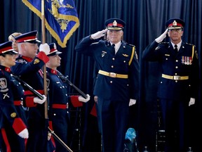 Chatham-Kent Police Chief Gary Conn, left and outgoing Chief Dennis Poole salute the newly consecrated colours of the police service during change of command ceremony at The Armoury in Chatham, Ont. on Friday May 22, 2015. (Diana Martin/Chatham Daily News/Postmedia Network)