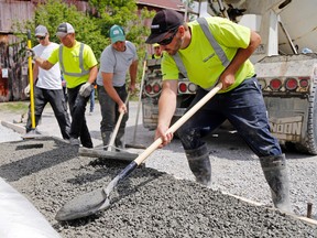 Luke Hendry/The Intelligencer 
Brandon Blemkie, right, of Stampkrete Concrete Contracting spreads a porous form of concrete in the Quinte Conservation parking lot in Quinte West Friday. Behind him from left are Cory McCormack, Casey Down and Eric Hannah.