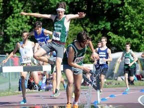 Jonathan Besselink, centre, of Holy Cross Catholic Secondary School clears the hurdle at the water pit during the open boys 2,000-metre steeplechase at the EOSSAA track and field championships Friday in Brockville. Besselink went on to win the vent in a time of 6:18.43. (Darcy Cheek/Postmedia Network)
