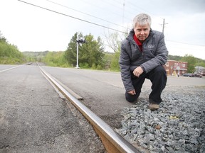 In this file photo, Jeff Walker, a professor in the School of Engineering at Cambrian College,examines a railway track in Sudbury. 
Gino Donato/Sudbury Star
