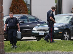 A Greater Sudbury Police forensic unit works the scene of a robbery at Desjardins Caisse Populaire in Azilda, Ont. on Friday May 22, 2015. John Lappa/Sudbury Star/Postmedia Network