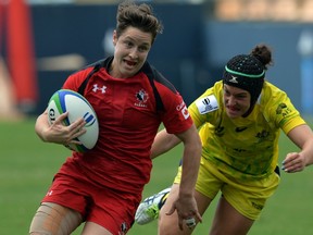 Ghislaine Landry (left) of Canada runs past a tackle from Emilee Cherry (right) of Australia during their IRB Women's Sevens World Series semifinal match in Barueri, Brazil on Feb. 8, 2015. (Nelson Almeida/AFP)