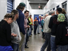 Bidders take a peak at the third abandoned or foreclosed storage unit up for auction at Access Storage on Saturday. Proceeds from the auction went to March of Dimes. Steph Crosier, The Whig-Standard, Postmedia Network.