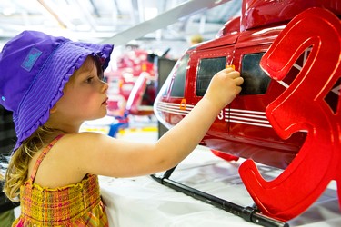 Three-year-old Katelyn checks out a replica STARS air ambulance during an open house at the Winnipeg hangar on the afternoon of Sat., May 23, 2015. (Brook Jones/Postmedia Network)