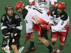 Edmonton RUSH #24 Ryan Dilks passes the ball as Calgary Roughnecks defenceman #14 Jeff Moleski and #3 Dan MacRae close in on him during second quarter action at Rexall Place on Friday May 15, 2015, in Edmonton Alta. Tom Braid/Edmonton Sun/Postmedia Network.