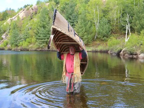 Marcel Labelle, of the Metis and Anishinaabe nations, prepares to launch a birchbark canoe during a ceremony at Lake Laurentian Conservation Area in Sudbury, Ont. on Friday May 22, 2015. Since February 2015, Labelle worked with Ecole secondaire du Sacre-Coeur students registered in the native education studies and woodshop programs to build the 13-foot canoe. Labelle stressed the importance of the canoe for Metis and First Nations communities during the building process.  John Lappa/Sudbury Star/Postmedia Network