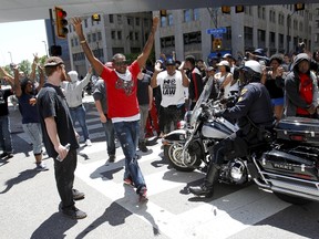 Protestors gather in a downtown intersection as a Cleveland Police officers block them from an RTA bus following the not guilty verdict for Cleveland police officer Michael Brelo on manslaughter charges in Cleveland, Ohio, May 23, 2015. REUTERS/Aaron Josefczyk