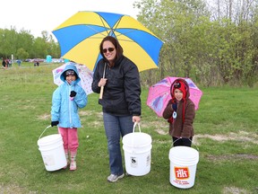 Darlene Deveau and her daughters, Jenna, 7, and Jorja, 5, carry buckets containing brook trout for a release into Junction Creek located at Twin Forks Playground at the Junction Creek Festival in Sudbury, Ont. on Saturday May 23, 2015. The Ontario Ministry of Natural Resources delivered 1,000 brook trout for the release. John Lappa/Sudbury Star/Postmedia Network