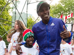 Eight-year-old Devlin Taillon looks up to his running mentor and hero David Kogei, who is an elite runner from Kenya, after they ran the Scotiabank Ottawa Kids Marathon together on Sunday May 24, 2015. Errol McGihon/Ottawa Sun/Postmedia Network