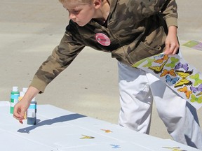 Cordel DeJong works on a poster during a Saturday protest at Sarnia city hall as part of a worldwide March Against Monsanto to raise awareness about genetically modified seeds and the chemicals used in agriculture. Photo taken Saturday, May 23, 2015 at Sarnia, Ontario. (NEIL BOWEN/ SARNIA OBSERVER/ POSTMEDIA NETWORK)