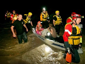 Mark Norris, walking in black t-shirt, Retha Norris, Ally Smith, 4, and Christina Norris (L to R), are rescued by firefighters after clinging to a tree at their home during flooding, in Kyle, Texas, United States May 24, 2015.  The National Weather Service warned that flash flooding was possible in parts of Oklahoma, Arkansas and Texas with heavy rainfall expected in a region already soaked by recent storms. REUTERS/Jay Janner/American-Statesman