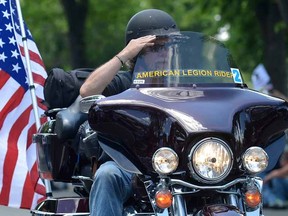 A biker with a U.S flag salutes crowds gathered during Rolling Thunder XXVII on Memorial Day weekend, as hundreds of thousands of bikers converge for a "Ride for Freedom" to remember POWs and MIAs and honor the nation's military, in Washington, May 25, 2014. REUTERS/Mike Theiler