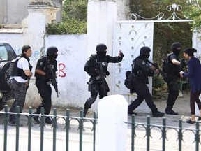 Tunisian anti-terrorism brigade personnel enter a house to take position after a shooting at the Bouchoucha military base in Tunis, Tunisia May 25, 2015.  REUTERS/Zoubeir Souissi