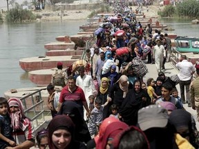 Displaced Sunni people fleeing the violence in Ramadi, cross a bridge on the outskirts of Baghdad, May 24, 2015.   REUTERS/Stringer