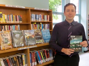 Kevin Coates, the adult services librarian at the Sarnia public library, shows off the book, The Girl on the Train, which remains the most popular fiction book at the library right now. Photo taken Monday, May 25, 2015 at Sarnia, Ontario. (CHRIS O’GORMAN/ SARNIA OBSERVER/ POSTMEDIA NETWORK)