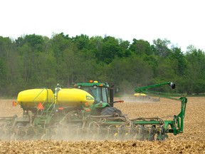Luke Gysbers, foreground, and Dave Cleve, in the other tractor, plant soybeans in a 150-acre field north of London. Although they planned to replant corn, the large amount of corn stalks that survived the winter made it too difficult, so beans were planted instead. (MIKE HENSEN, The London Free Press)