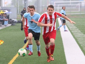 Alex Cholewinsky, left, of St. Benedict Bears, and Max Leduc, of Macdonald-Cartier Pantheres, chase after the ball during semifinal action in the high school boys premier soccer division action at James Jerome Sports Complex in Sudbury, Ont. on Monday May 25, 2015. John Lappa/Sudbury Star/Postmedia Network