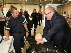 Advanced care paramedic Luc Simard, left, gives Greater Sudbury Mayor Brian Bigger a few tips while the mayor performs hands only CPR compressions at a demonstration at the launch of Paramedic Week at the Lionel E. Lalonde Centre in Azilda, Ont. on Monday May 25, 2015. John Lappa/Sudbury Star/Postmedia Network