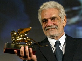 Egyptian actor Omar Sharif holds up the Golden Lion lifetime achievment award, at the Venice Film Festival August 29, 2003. (Reuters file photo)