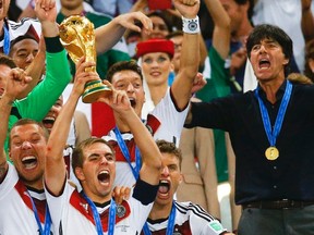 Germany's Philipp Lahm lifts the World Cup trophy as he celebrates with team mates and coach Joachim Loew (R) after winning the 2014 World Cup final against Argentina at the Maracana stadium in Rio de Janeiro in this July 13, 2014 file picture. (REUTERS/Kai Pfaffenbach/File)