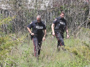 Police officers look through a wooded area of Cataraqui Woods, in Kingston, Ont. on Tues., May 26, 2015, searching for a boy who was reported missing that morning. He was later found safe. Michael Lea/The Whig-Standard/Postmedia Network