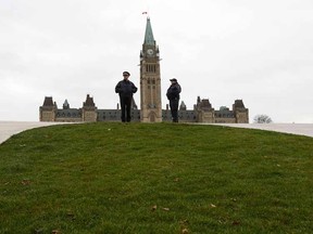 Royal Canadian Mounted Police officers stand guard on Parliament Hill in Ottawa October 23, 2014. A gunman attacked Canada's parliament on Wednesday, with gunfire erupting near a room where Prime Minister Stephen Harper was speaking, and a soldier was fatally shot at a nearby war memorial, jolting the Canadian capital.  REUTERS/Chris Wattie