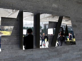 Journalists are reflected in the FIFA logo as they wait for a news conference after a meeting of the FIFA executive committee in Zurich March 20, 2015. REUTERS/Arnd Wiegmann