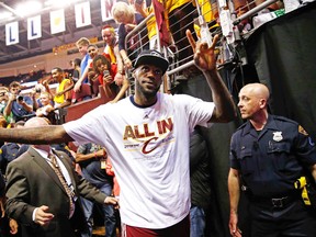LeBron James high-fives with Cleveland fans after advancing to the NBA Finals on Tuesday night. (AFP)