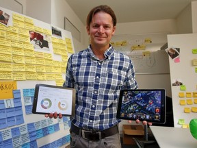 Dave Bruno, head of the innovation lab at Swiss bank UBS, poses with two tablet computers in his office in Zurich Jan. 16, 2015. REUTERS/Arnd Wiegmann