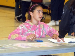 Walpole Island Elementary School student Angel Riley calculates her expenses at a station during a financial stimulation program called The Student Reality Store held at WIES on Wednesday, May 20. The program teaches students the importance of good grades and post-secondary education and how it will affect their income when they become adults.