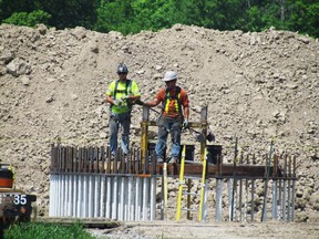 Construction of Suncor and NextEra's 46-turbine Cedar Point wind energy project is underway in Lambton County. A crew works on a turbine foundation next to Hillsboro Road in Plympton-Wyoming on Thursday May 28, 2015 near Sarnia, Ont. (Paul Morden/Sarnia Observer/Postmedia Network)