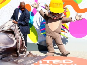 Retired Canadian sprinter Donovan Bailey with Pan Am mascot Pachi during the unveiling of the Pan Am Games medal podiums at Nathan Phillips Square on Thursday May 28, 2015. (Dave Abel/Toronto Sun)