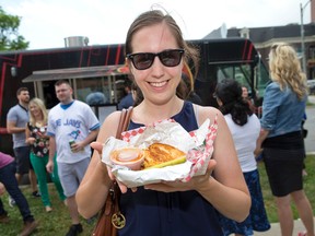 Is there an appetite for food trucks in London? Goodah Gastro Truck customer Caitlin Harris seems to enjoy the grilled cheese she bought on Queens Ave. this week. (CRAIG GLOVER, The London Free Press)