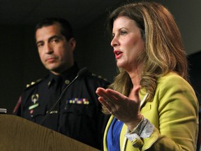 Then-federal Health Minister Rona Ambrose speaks as Calgary Police Deputy Chief Trevor Deroux (L) listens during a press conference in Calgary, Alta to launch public service announcements to battle prescription drug abuse on Thursday, May 28, 2015. Jim Wells/Calgary Sun/Postmedia Network