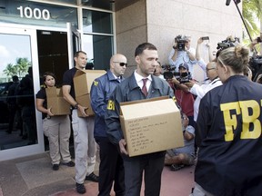 FBI agents bring out boxes after an operation inside the CONCACAF (Confederation of North, Central America and Caribbean Association Football) offices in Miami Beach, Florida May 27, 2015. The world's most popular sport was plunged into turmoil on Wednesday as seven powerful soccer figures were arrested on U.S. corruption charges and faced extradition from Switzerland, whose authorities also announced a criminal investigation into the awarding of the next two World Cups. The arrests in a dawn raid at a five-star Zurich hotel mark an unprecedented blow against soccer's governing body FIFA, which for years has been dogged by allegations of corruption but always escaped major criminal cases.  REUTERS/Javier Galeano