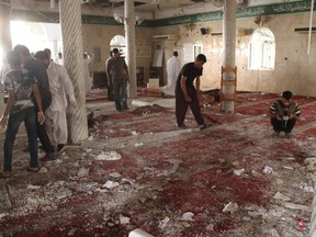 People examine the debris after a suicide bomb attack at the Imam Ali mosque in the village of al-Qadeeh in the eastern province of Gatif, Saudi Arabia, May 22, 2015. A suicide bomber killed 21 worshippers during Friday prayers in the packed Shi'ite mosque in eastern Saudi Arabia, residents and the health minister said, in an attack claimed by the Islamic State militant group. REUTERS
