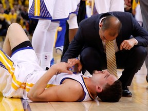 Klay Thompson of the Golden State Warriors is check on after being injured during Game 5 of the Western Conference final against the Houston Rockets at ORACLE Arena on May 27, 2015 in Oakland. (Ezra Shaw/Getty Images/AFP)