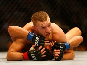 Conor McGregor pins down Max Holloway in their UFC featherweight bout at TD Garden on August 17, 2013 in Boston. (Jared Wickerham/Getty Images/AFP)