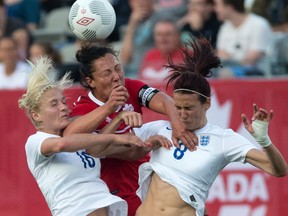 Canada’s Melissa Tancredi (centre) battles in the air against England’s Jill Scott (right) and Katie Chapman in Hamilton last night. Canada kicks off its World Cup next Saturday vs. China. (Craig Robertson/Toronto Sun)