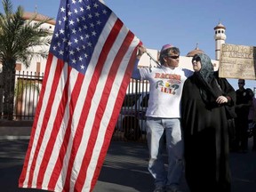 Two demonstrators stand in front of the Islamic Community Center to oppose the "Freedom of Speech Rally Round II" across the street in Phoenix, Arizona May 29, 2015. Arizona police stepped up security near a mosque on Friday ahead of a planned anti-Islam demonstration featuring displays of cartoons of the Prophet Mohammad, weeks after a similar contest in Texas came under attack from two gunmen.  REUTERS/Nancy Wiechec