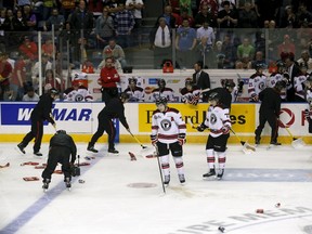 Workers clean the ice after fans threw garbage during the second period of the semi-final Memorial Cup hockey game between the Quebec Remparts and the Kelowna Rockets at the Colisee Pepsi on May 29, 2015. (REUTERS/Mathieu Belanger)