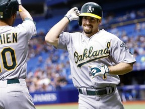 Billy Burns is congratulated by teammate Marcus Semien after hitting his first major-league home last weekend against Tampa Bay. (AFP)