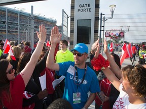 UNICEF Canada team members high-five amongst themselves and with fans arriving for the Women's World Cup Soccer friendly match between Canada and England at Tim Horton's Field in Hamilton, Ontario on May 29, 2015. (Peter Power/UNICEF Canada)