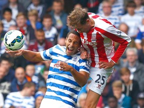 Queens Park Rangers’ Rio Ferdinand (left) challenges Stoke City’s Peter Crouch during their English Premier League match at Loftus Road in London September 20, 2014. (REUTERS/Eddie Keogh)