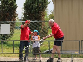 Braxtyn Lester, 7, of Sarnia, reels in a rainbow trout with the help of volunteers Pete Bothwell, left, and Ralph Eves on Saturday May 30, 2015 in Point Edward, Ont. The Bluewater Anglers welcomed 150 children to try their hand at fishing and learn about water safety during the club's annual Kids Training Day held at the hatchery. Barbara Simpson/Sarnia Observer/Postmedia Network