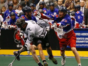 Edmonton's Zach Greer gets checked by former Rush player Brodie Merrill during Game 1 of the NLL final Saturday in Toronto (Jack Boland, Postmedia Network).