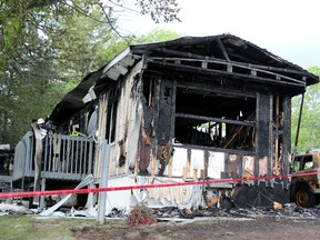 The remains of a mobile-home in Millhaven after a Kingston man allegedly lit it on fire with three people inside. OPP have charged him with attempted murder in Napanee, Ont. on Saturday May 30, 2015. Steph Crosier/Kingston Whig-Standard/Postmedia Network